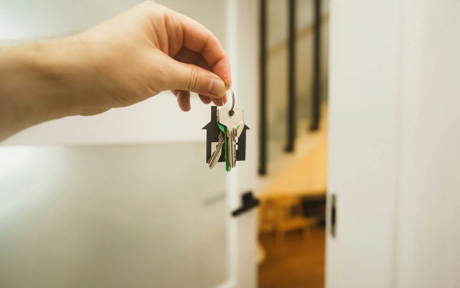 Mano con una chiave davanti alla porta di un appartamento: check-in di un affitto breve in condominio