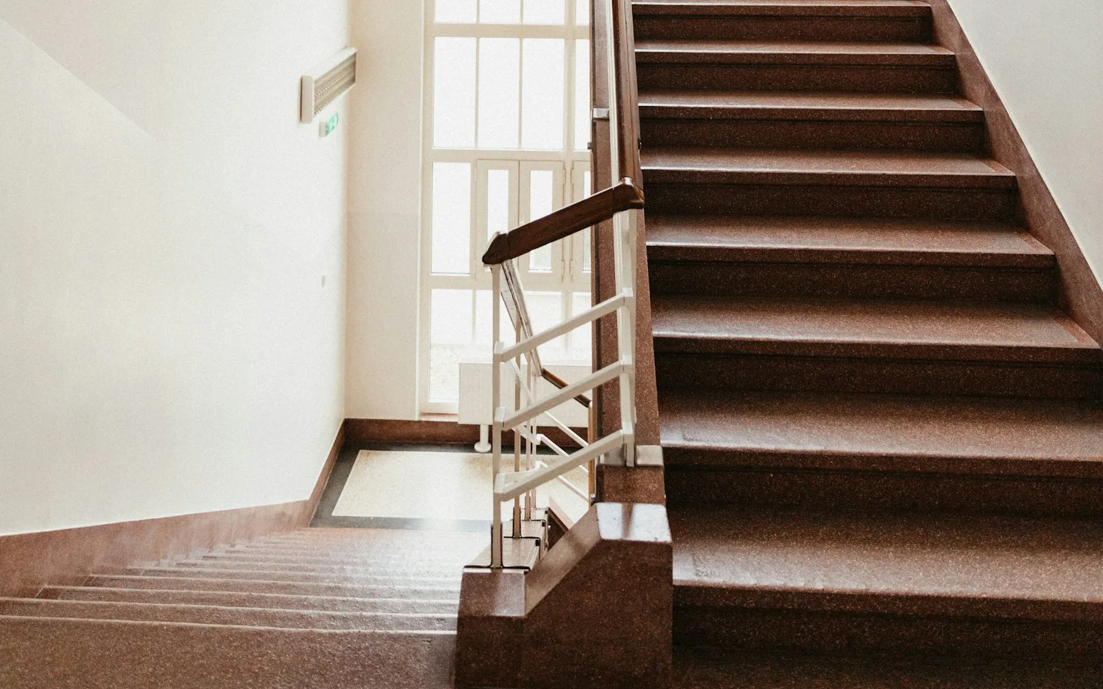 Scala interna di un palazzo residenziale con gradini e corrimano.