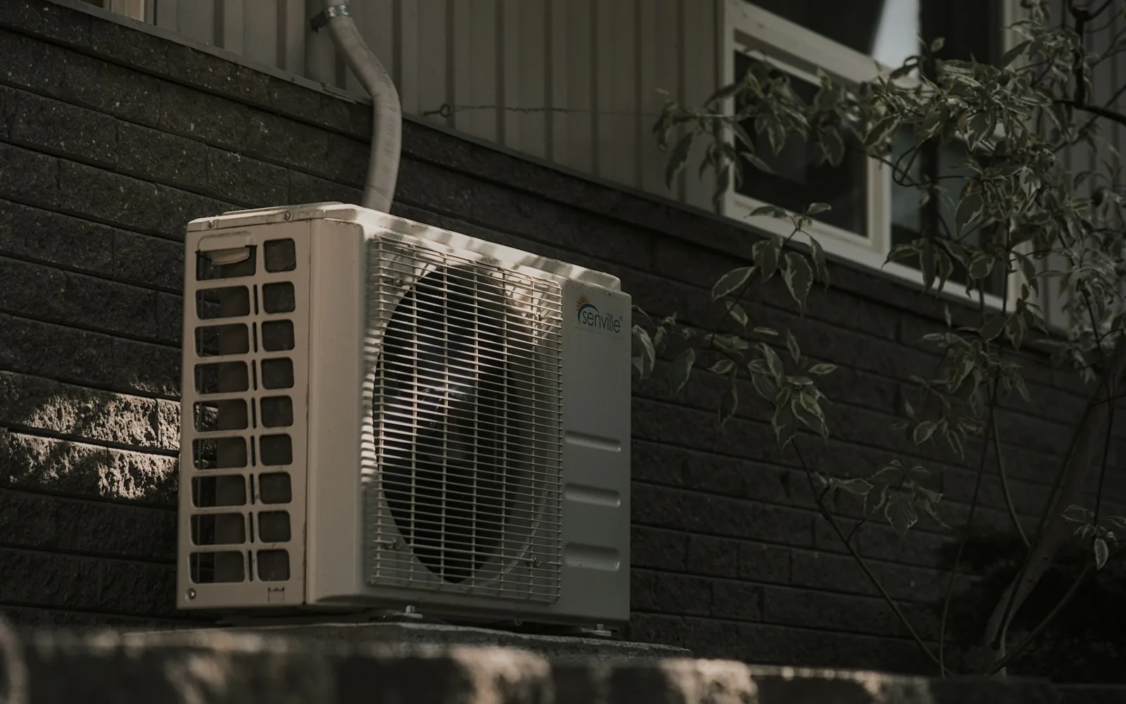 Unità esterna di un condizionatore installata sulla facciata di un edificio residenziale.