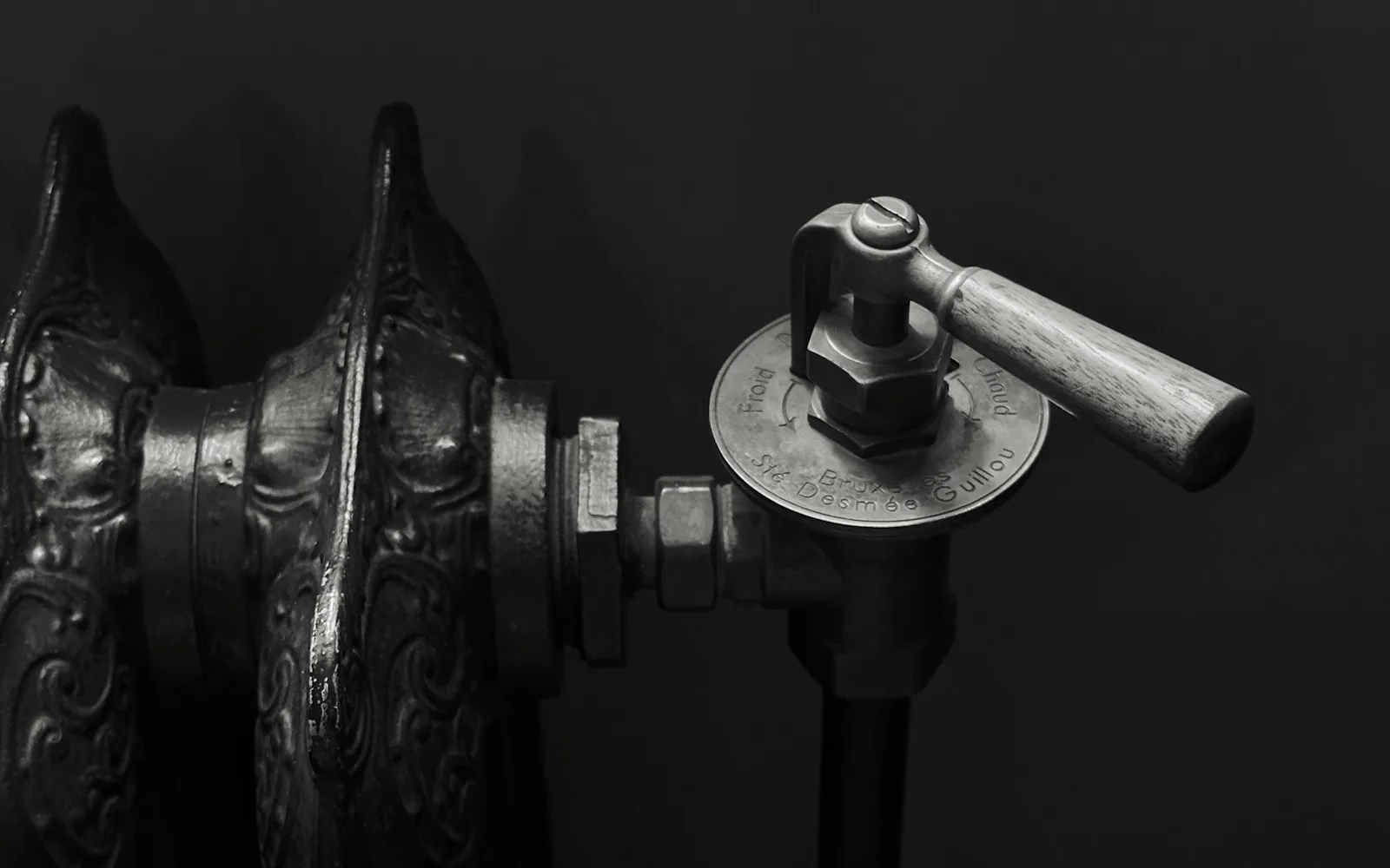 Termosifone in ghisa decorato con la manopola della valvola di regolazione in primo piano.
