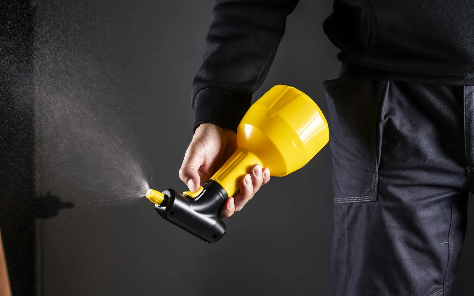 Operatore che utilizza un nebulizzatore giallo per un trattamento di disinfestazione.
