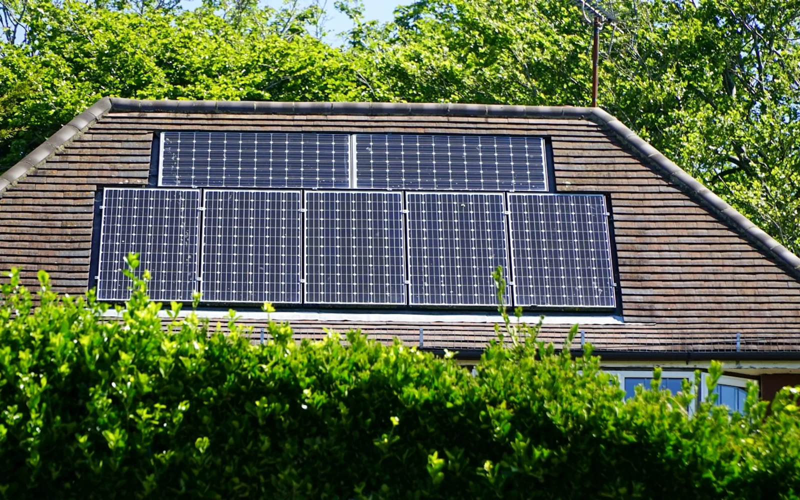 Pannelli fotovoltaici installati sulla falda in tegole del tetto di un edificio.