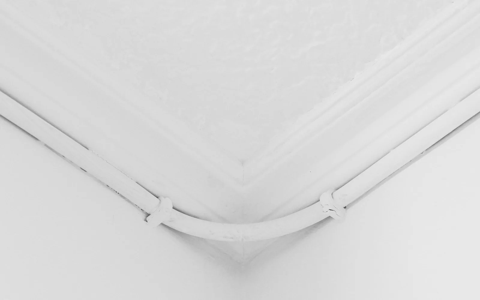 Angolo di un soffitto con cornice in gesso in una stanza vuota.