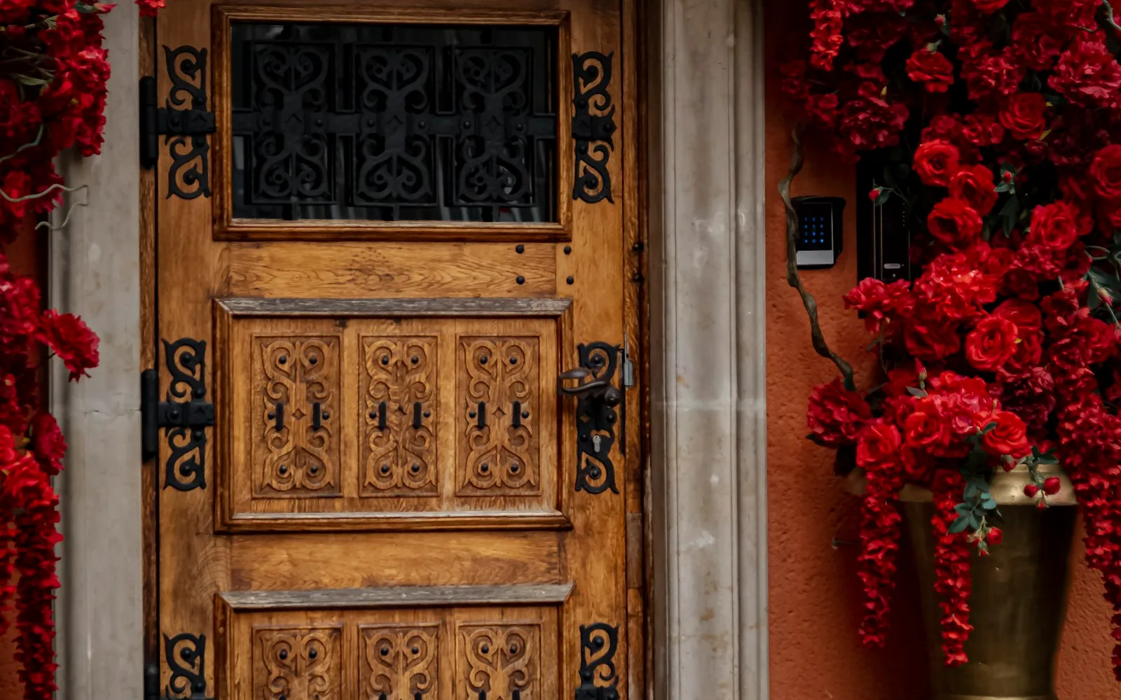 Portone d'ingresso in legno di un edificio residenziale, con citofono a lato.