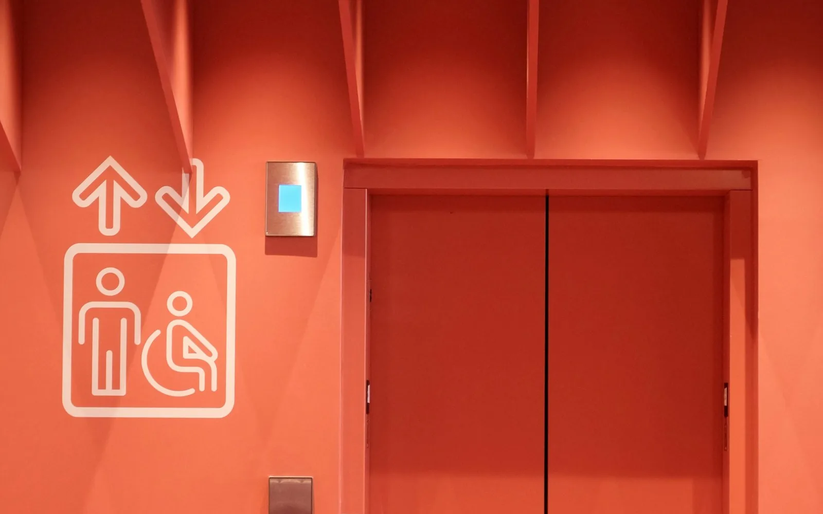 Porte di un ascensore con pulsantiera e simbolo di accessibilità.
